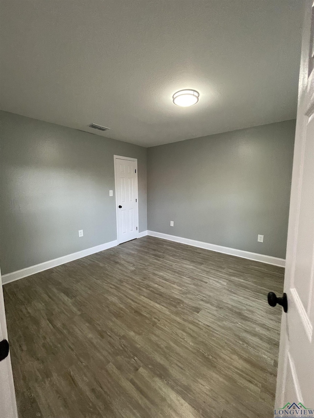 220 Myrle Ave, Longview, TX 75602 - empty room with dark wood-style floors and baseboards
