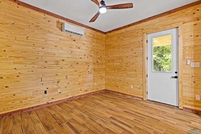 empty room featuring an AC wall unit, wooden walls, ceiling fan, and light hardwood / wood-style flooring