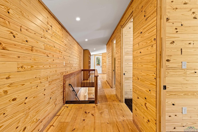 hallway with wooden walls and light hardwood / wood-style floors