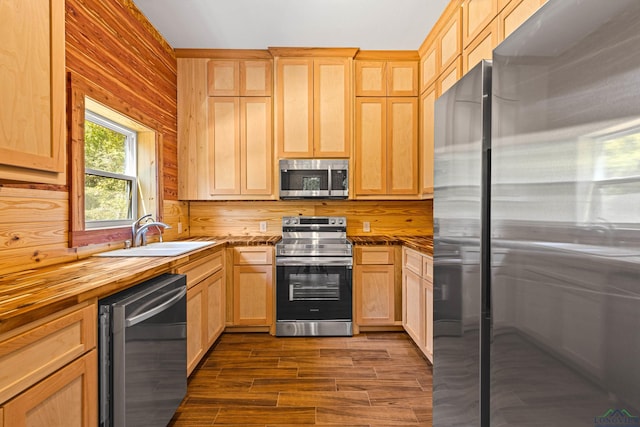 kitchen with sink, stainless steel appliances, dark hardwood / wood-style floors, wood counters, and light brown cabinets