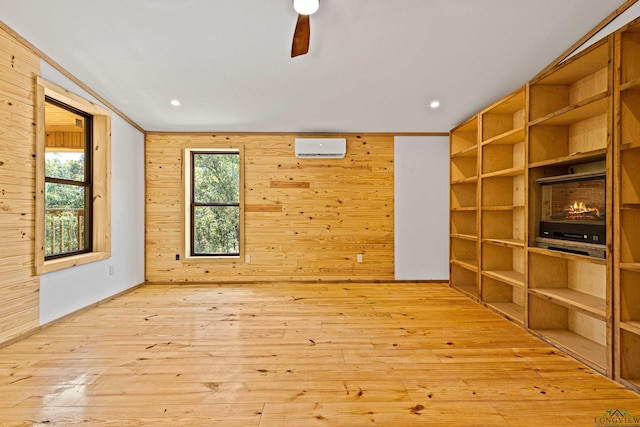 interior space featuring ceiling fan, wooden walls, and light hardwood / wood-style floors