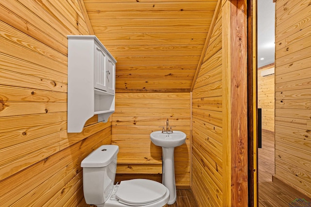 bathroom featuring wooden walls and toilet