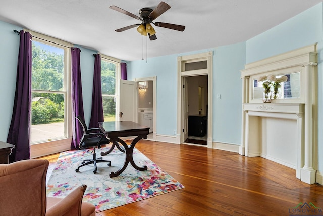 office with baseboards, wood-type flooring, and a ceiling fan