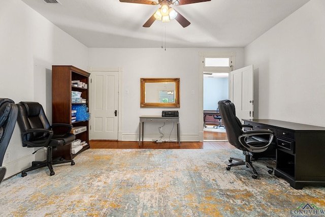 office space with baseboards, ceiling fan, wood finished floors, and visible vents
