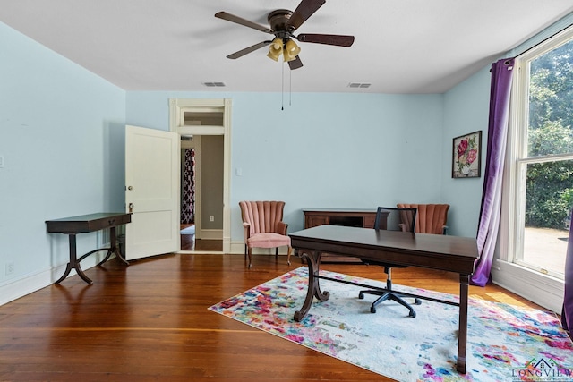 office space featuring visible vents, a ceiling fan, baseboards, and wood finished floors