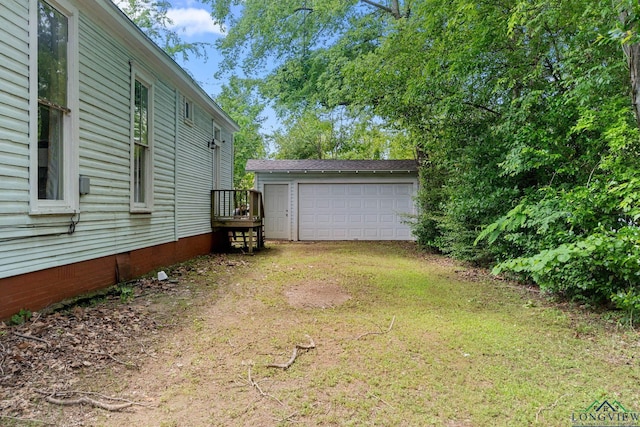 view of yard with a detached garage and an outbuilding