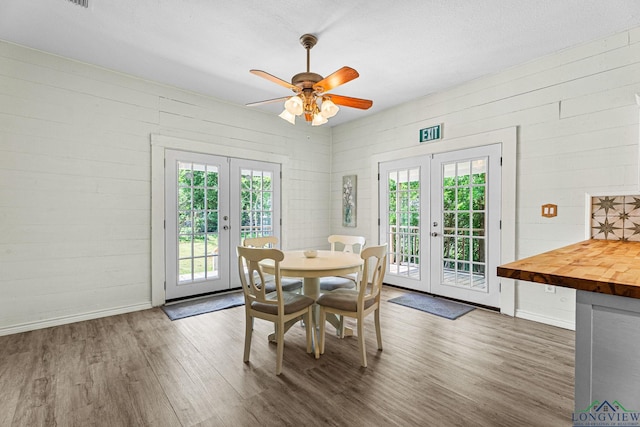 dining area featuring a ceiling fan, french doors, wood finished floors, and a wealth of natural light
