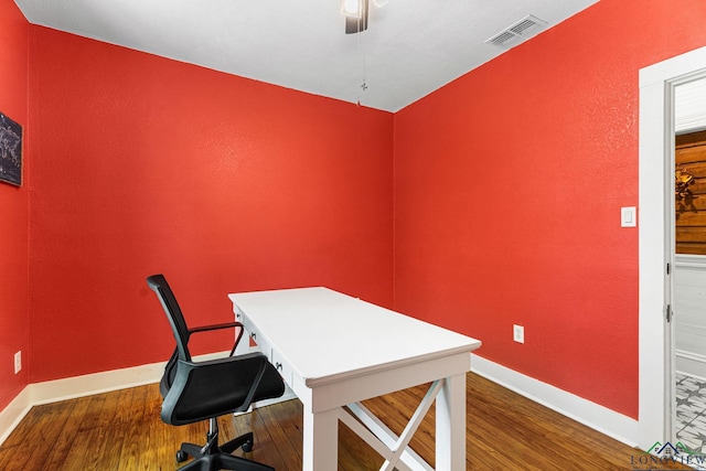 office area featuring a ceiling fan, baseboards, visible vents, and wood finished floors