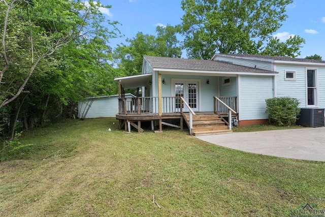 view of front facade featuring roof with shingles, a front lawn, french doors, a porch, and central air condition unit