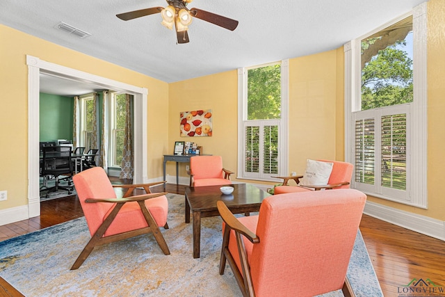 sitting room featuring a ceiling fan, baseboards, visible vents, and hardwood / wood-style flooring