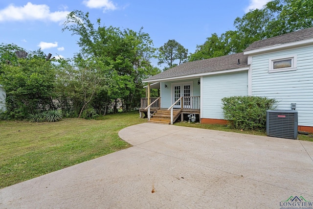 view of front of home featuring crawl space, french doors, a front yard, central AC unit, and a shingled roof