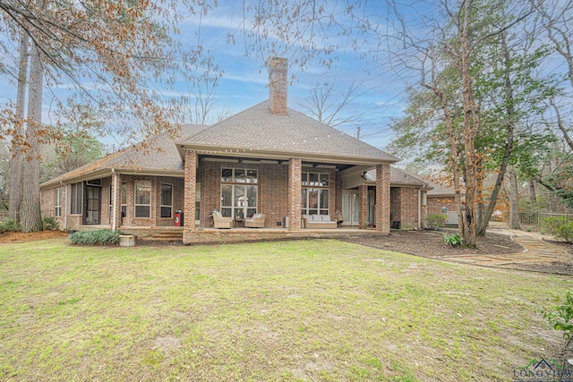 rear view of property with a yard and a sunroom