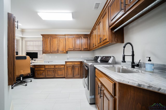 laundry room featuring cabinets, ornamental molding, sink, and washer and dryer