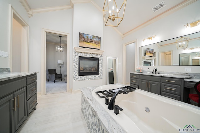 bathroom with crown molding, vanity, tiled bath, and a chandelier