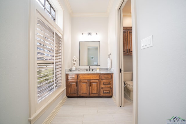 bathroom with vanity, crown molding, and toilet