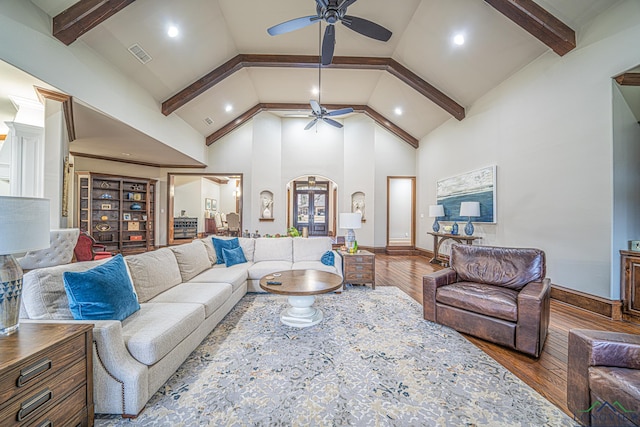 living room featuring hardwood / wood-style flooring, ceiling fan, high vaulted ceiling, and beamed ceiling