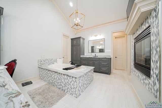 bathroom featuring high vaulted ceiling, a bathtub, a chandelier, vanity, and crown molding