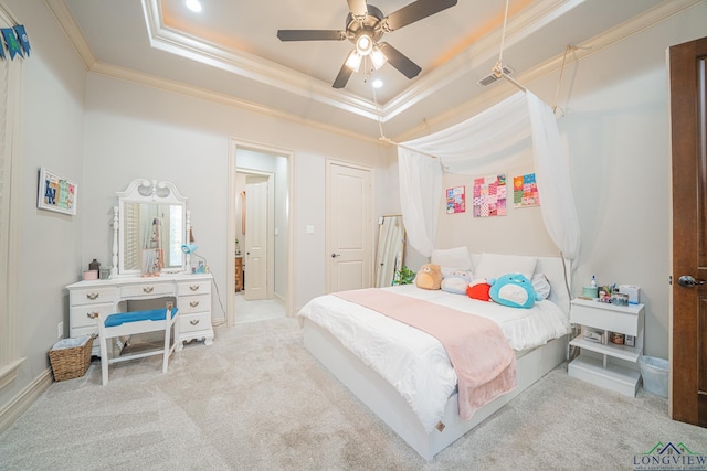 bedroom with ceiling fan, ensuite bathroom, ornamental molding, light carpet, and a raised ceiling