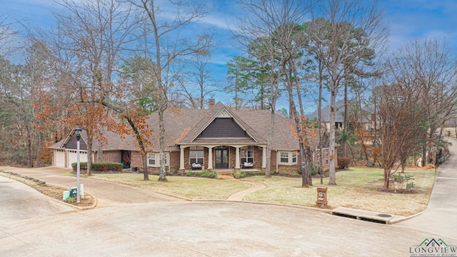 view of front of house with a garage, a front yard, and covered porch