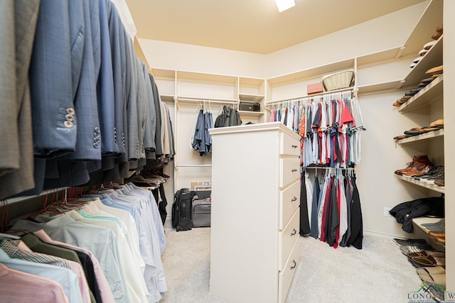 walk in closet with light carpet