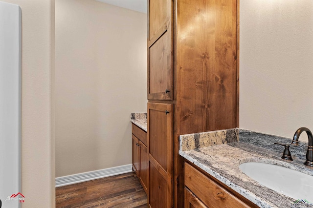 bathroom featuring vanity, wood finished floors, and baseboards