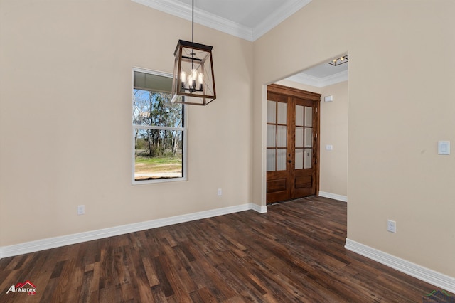 unfurnished dining area featuring dark wood finished floors, french doors, an inviting chandelier, crown molding, and baseboards