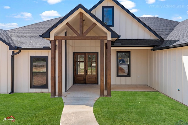 doorway to property with french doors, roof with shingles, board and batten siding, and a lawn