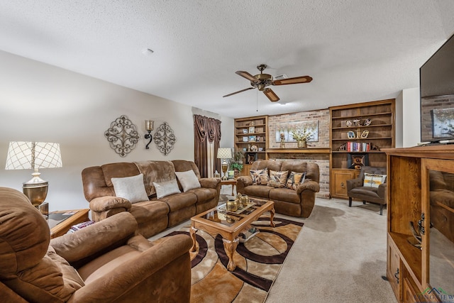 carpeted living room with ceiling fan, built in shelves, and a textured ceiling