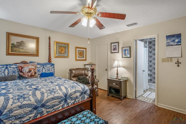 bedroom featuring hardwood / wood-style floors, connected bathroom, a textured ceiling, and ceiling fan