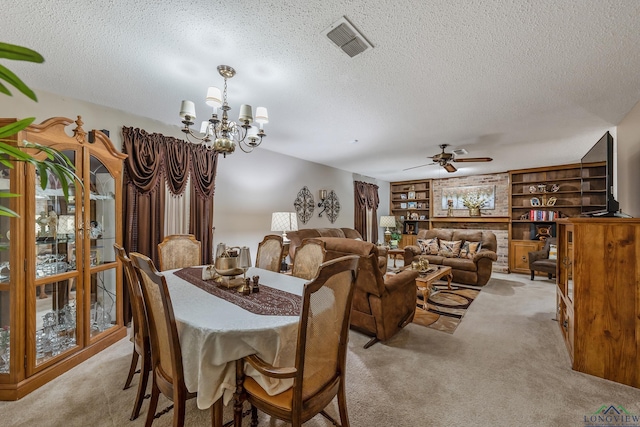 dining space featuring light colored carpet, ceiling fan with notable chandelier, built in features, and a textured ceiling