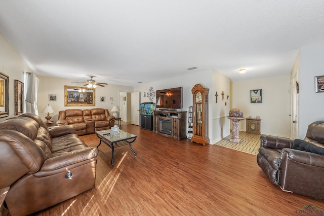 living room with hardwood / wood-style floors, a textured ceiling, and ceiling fan