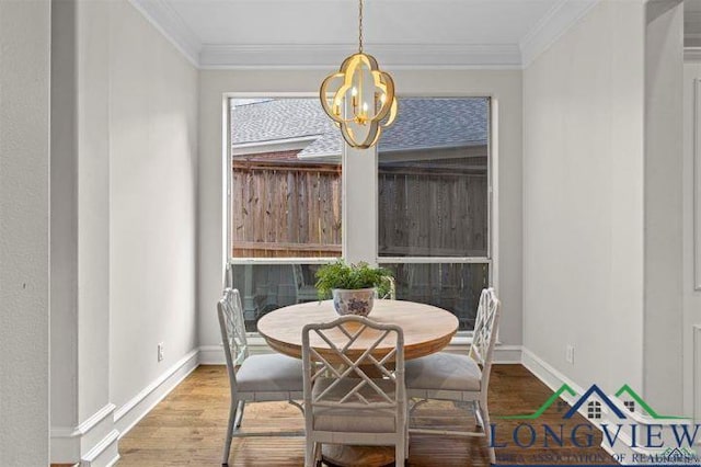 dining area featuring wood-type flooring, an inviting chandelier, and ornamental molding