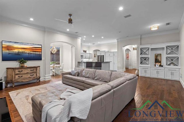 living room featuring ceiling fan, crown molding, and dark wood-type flooring