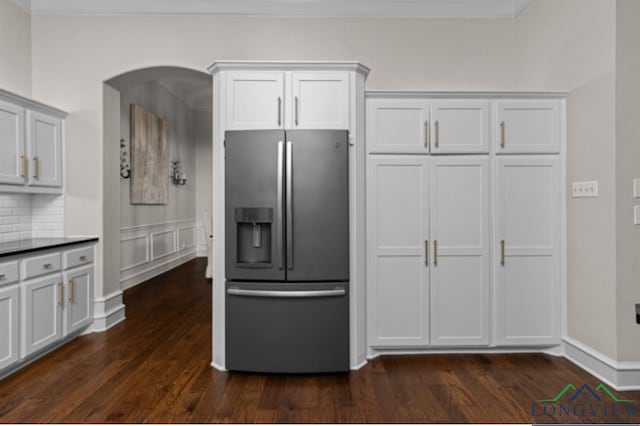 kitchen featuring stainless steel fridge and white cabinetry