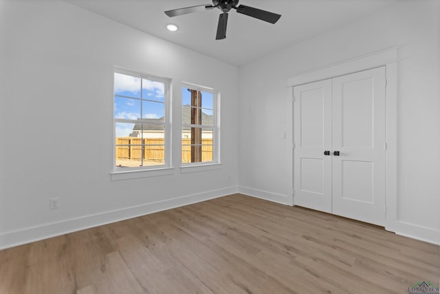 unfurnished bedroom featuring light wood finished floors, ceiling fan, baseboards, and a closet