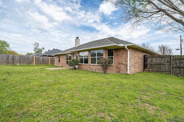 207 Willow Rd, Bullard, TX 75757 - back of house with a patio area, a chimney, brick siding, a fenced backyard, and a lawn
