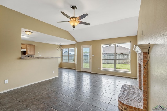 207 Willow Rd, Bullard, TX 75757 - unfurnished living room featuring ceiling fan with notable chandelier, lofted ceiling, dark tile patterned floors, and baseboards