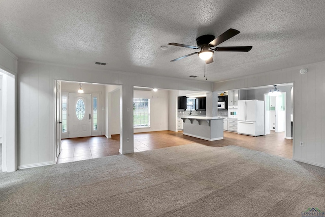 3897 Lansing Switch Rd, Longview, TX 75602 - unfurnished living room featuring light colored carpet, light tile patterned floors, and a textured ceiling