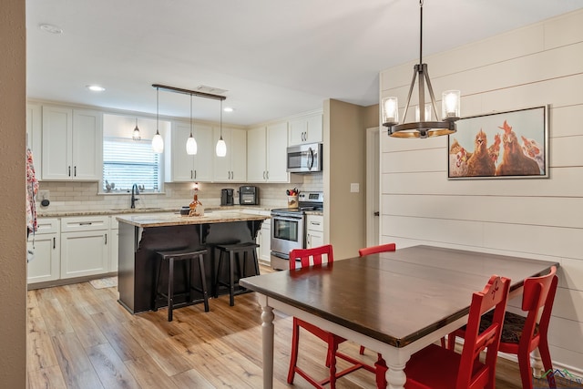 dining room featuring light hardwood / wood-style floors, a notable chandelier, and sink