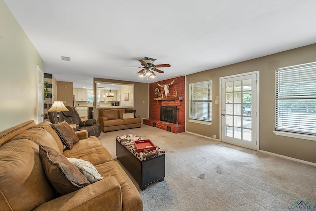 living room featuring carpet, a brick fireplace, and ceiling fan