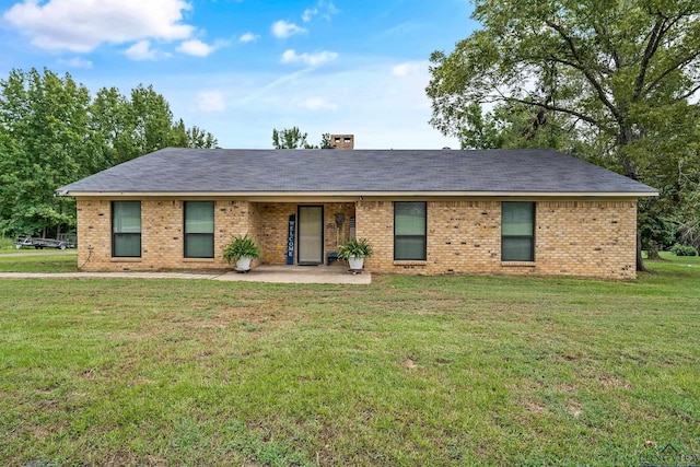 single story home featuring a front lawn and a patio area