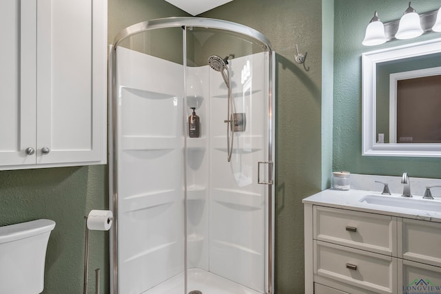 bathroom featuring vanity, toilet, and an enclosed shower