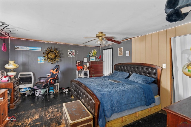 bedroom featuring heating unit, ceiling fan, and wooden walls