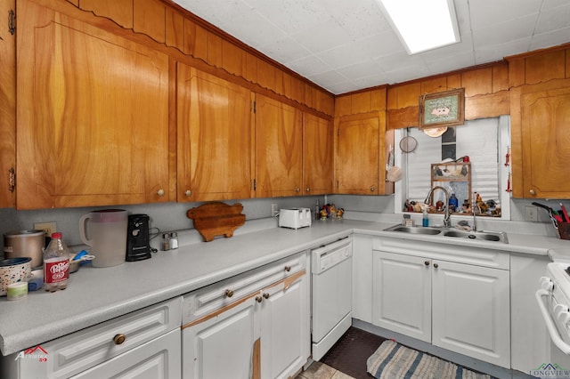 kitchen with dishwasher, stove, white cabinetry, and sink