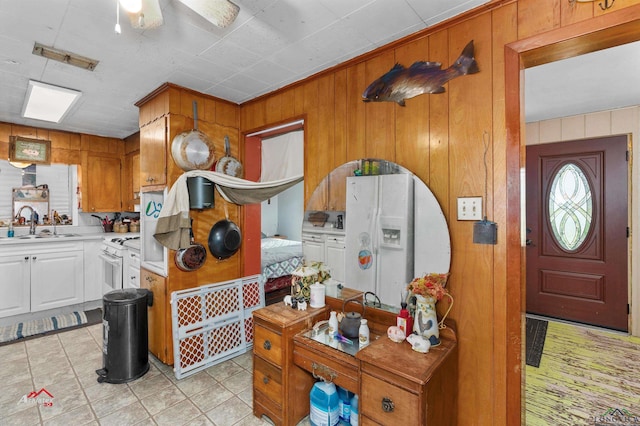 kitchen featuring ceiling fan, wood walls, white range oven, and sink