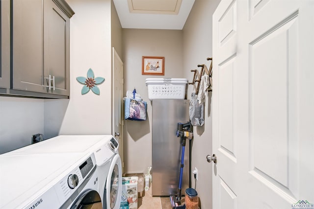 clothes washing area featuring cabinets, washer and dryer, and light tile patterned flooring