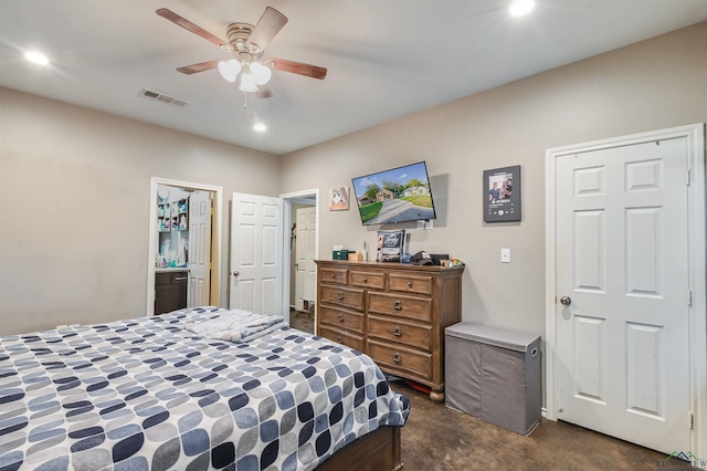 bedroom with ceiling fan, ensuite bathroom, and dark colored carpet