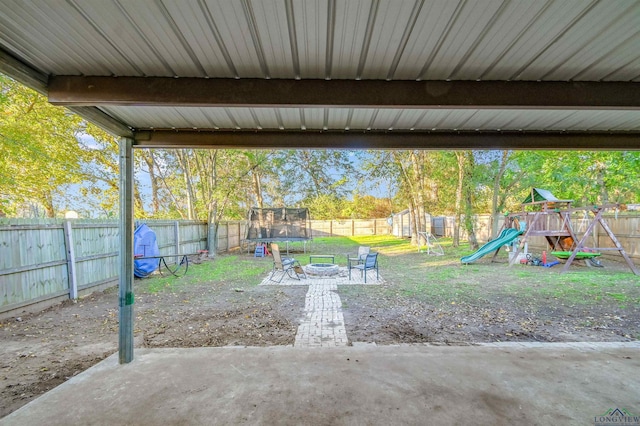 view of patio with a playground, a trampoline, and a fire pit