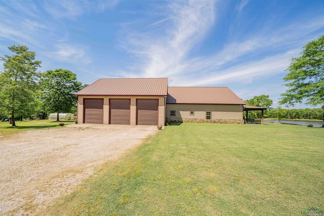 4754 Deer Rd, Gilmer, TX 75644 - view of front of home with driveway, a front yard, an outbuilding, and metal roof