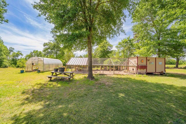 4754 Deer Rd, Gilmer, TX 75644 - view of yard featuring an outbuilding, a greenhouse, and exterior structure